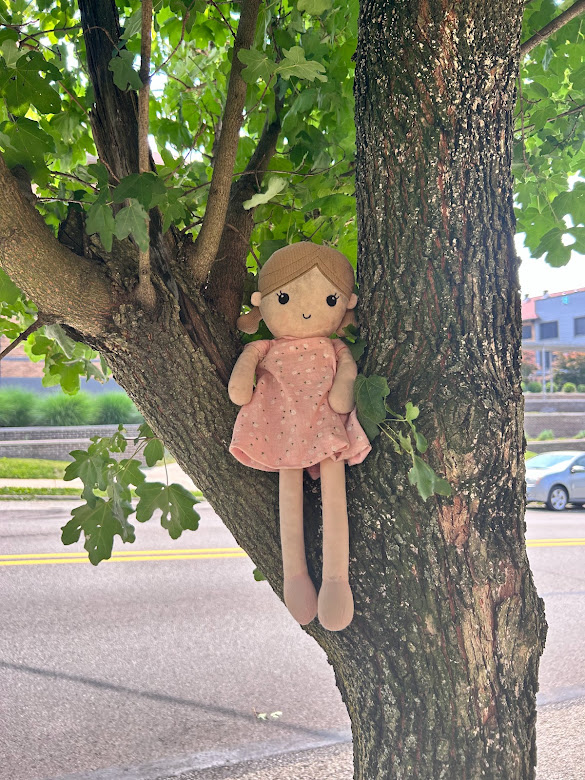 doll sitting in tree
